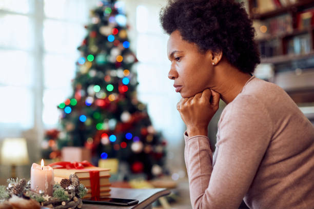 woman looking pensive or sad near the Christmas tree